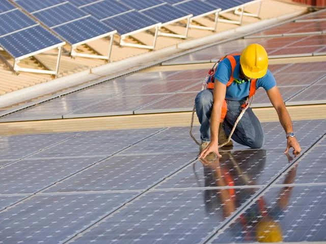 Technicien ajustant un panneau solaire sur une toiture